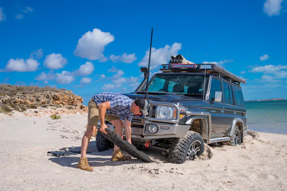 4x4 being recovered from beach using recovery tracks